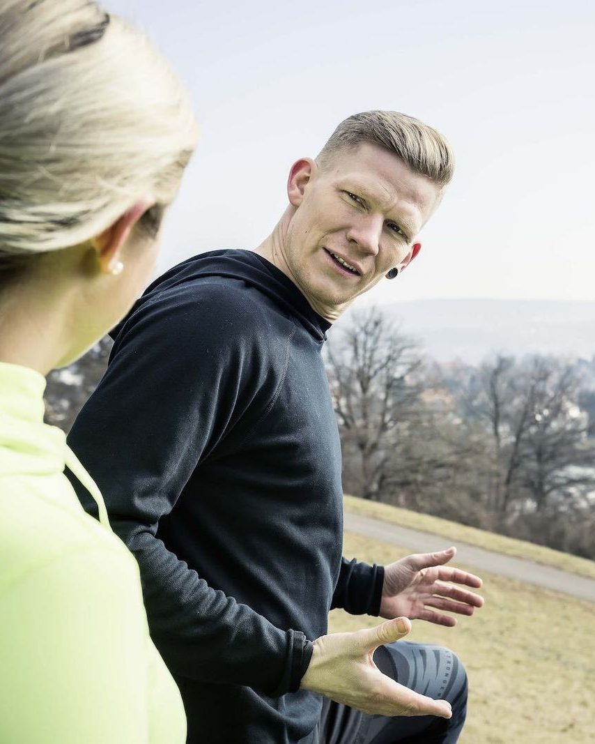 Florian Schwab erklärt einer Klientin eine Übung beim Training im Freien
